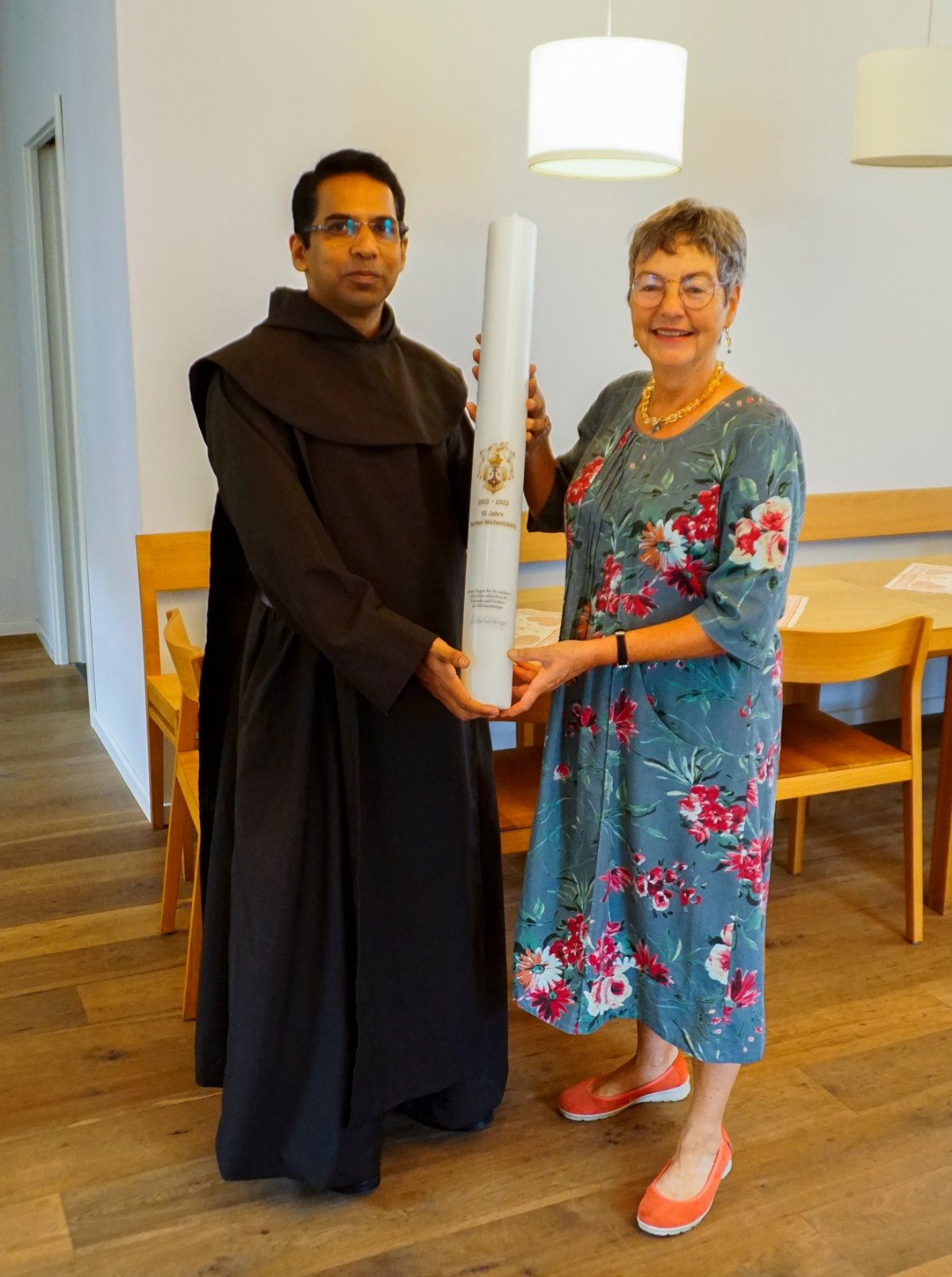 Dr. Andrea Korte-Böger, Vorsitzende des Vereins der Freund und Förderer des Michaelsberges e.V., übergibt die Kerze an Prior Pater Dr. Rockson Chullickal Vakkachan OCD (c) Sebastian Felske